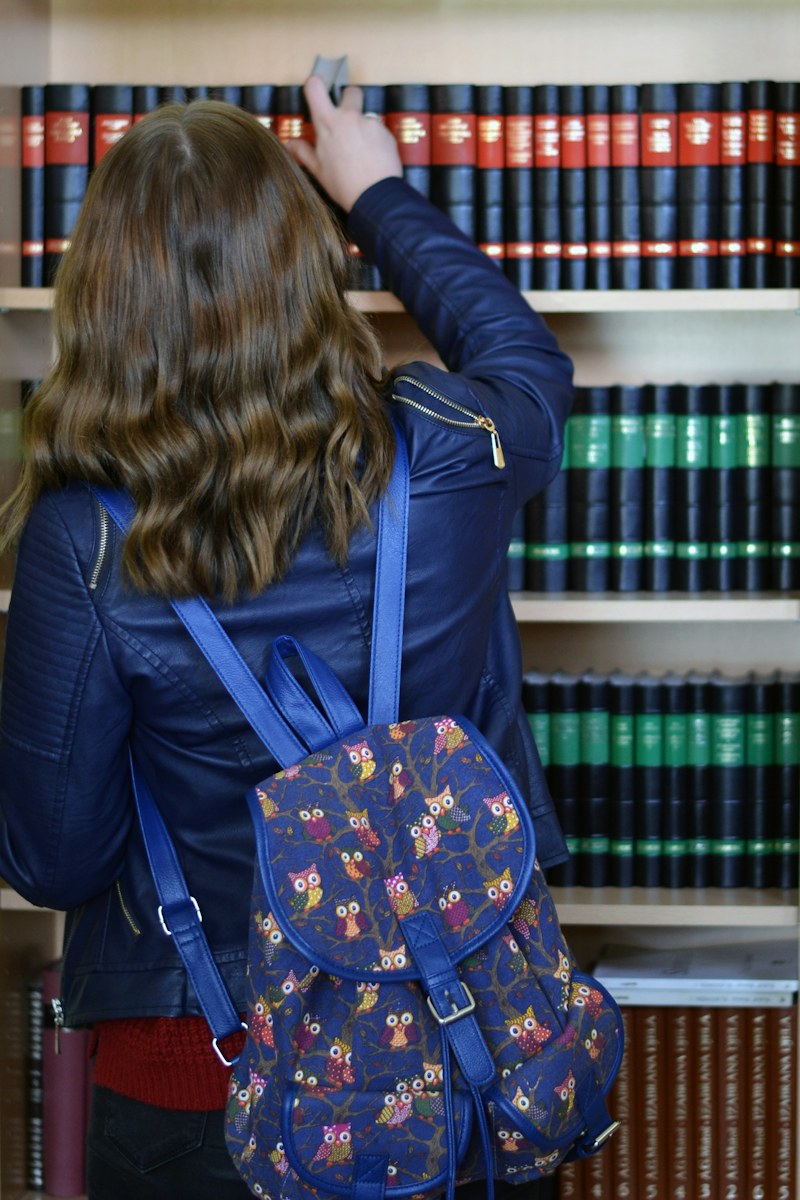 Devojka sa rancem pred policama biblioteke